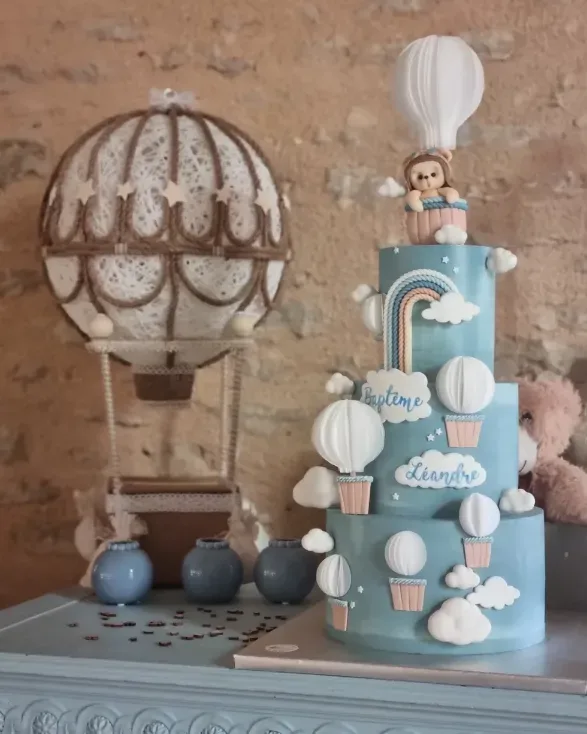 Pièce montée de baptême sur le thème montgolfières dans les nuages avec décor vintage en arrière-plan